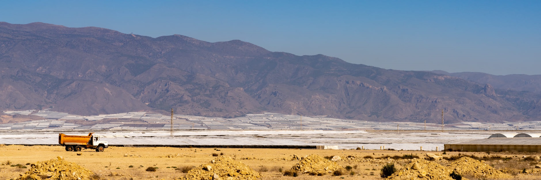 Almerimar, España: paisaje desértico con muchos invernaderos de plástico y un viejo camión abandonado